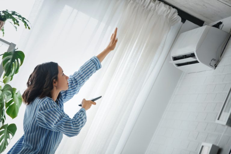 Woman checking AC is working or not at the home