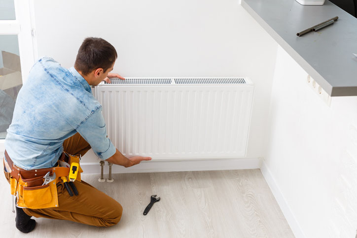 A worker installing a new radiator for a house in Annapolis, MD
