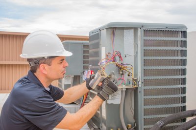 Technician in blue color uniform and repairing HVAC