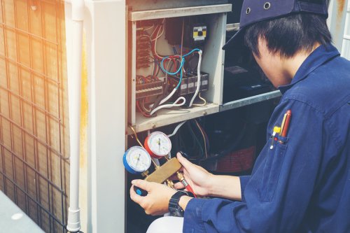 Technician in blue color uniform and repairing HVAC