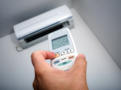 changing the temperature with help of remote in front of air conditioner