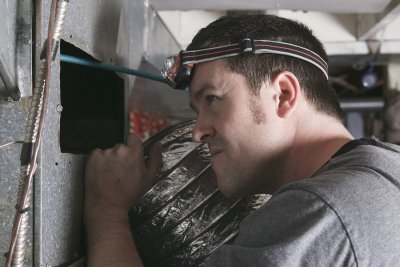 Technician repairing the heating system and attached torch on the head