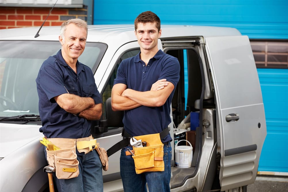 Technicians standing in front of the commercial van and looking at the camera